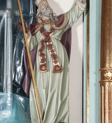 Zdjęcie nr 7: Nastawa architektoniczna, jednoosiowa, jednokondygnacyjna ze zwieńczeniem. Ołtarz drewniany, prostopadłościenny, z drewnianą mensą, ustawiony na profilowanym cokole. Ścianka frontowa ujęta pilastrami z płycinami w partii trzonów z akantem. W polu dwie płyciny o fantazyjnej formie wypełnione stylizowanym ornamentem akantowym, flankujące medalion z inicjałami „MS”. Ścianki boczne dekorowane płycinami. 
Na ołtarzu ustawione tabernakulum w formie drewnianej skrzynki, na cokole, flankowanej spływami wolutowymi, zwieńczonej szczytem zamkniętym łukowatym fragmentem gzymsu z płyciną i uskrzydloną główką anielską w polu. Drzwiczki w kształciestojącego prostokąta zamkniętego łukiem falistym, ujęte profilowaną ramą z przedstawieniem kielicha z hostią. 
Nastawa na cokole z wyodrębnionymi dwoma prostopadłościanami i dwoma skrajnymi konsolami, dekorowanym płycinami ze stylizowanym ornamentem. Retabulum ujęte parą kolumn o trzonach kanelowanych w jednej trzeciej wysokości, podtrzymujących belkowanie o architrawie i fryzie przerwanym nad polem środkowym. Na belkowaniu fragmenty przerwanego, półkolistego przyczółka z siedzącymi puttami. Niemal całe pole główne wypełnione wnęką w formie stojącego prostokąta zamkniętego łukiem półkolistym nadwieszonym, z uskokiem, w profilowanej ramie, z obrazami komunii anielskiej św. Stanisława Kostki i św. Józefa na zasuwie. Na konsolach, po bokach nastawy ustawione figury św. Wojciecha i św. Stanisława. Zwieńczenie w formie zbliżonej do stojącego prostokąta, ujętego spływami wolutowymi, zamkniętego dwiema stykającymi się wolutami oraz dwiema uskrzydlonymi główkami anielskimi w glorii promienistej. W polu obraz św. Rozalii w kształcie zbliżonym do zwieńczenia, ujęty profilowaną ramą. Struktura polichromowana w kolorze seledynowym, kolumny, profile i ornamentyka złocone. 


