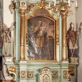 Zdjęcie nr 1: Nastawa architektoniczna, jednoosiowa, jednokondygnacyjna ze zwieńczeniem. Ołtarz drewniany, prostopadłościenny, z drewnianą mensą, ustawiony na profilowanym cokole. Ścianka frontowa ujęta pilastrami z płycinami w partii trzonów z akantem. W polu dwie płyciny o fantazyjnej formie wypełnione stylizowanym ornamentem akantowym, flankujące medalion z inicjałami „MS”. Ścianki boczne dekorowane płycinami. 
Na ołtarzu ustawione tabernakulum w formie drewnianej skrzynki, na cokole, flankowanej spływami wolutowymi, zwieńczonej szczytem zamkniętym łukowatym fragmentem gzymsu z płyciną i uskrzydloną główką anielską w polu. Drzwiczki w kształciestojącego prostokąta zamkniętego łukiem falistym, ujęte profilowaną ramą z przedstawieniem kielicha z hostią. 
Nastawa na cokole z wyodrębnionymi dwoma prostopadłościanami i dwoma skrajnymi konsolami, dekorowanym płycinami ze stylizowanym ornamentem. Retabulum ujęte parą kolumn o trzonach kanelowanych w jednej trzeciej wysokości, podtrzymujących belkowanie o architrawie i fryzie przerwanym nad polem środkowym. Na belkowaniu fragmenty przerwanego, półkolistego przyczółka z siedzącymi puttami. Niemal całe pole główne wypełnione wnęką w formie stojącego prostokąta zamkniętego łukiem półkolistym nadwieszonym, z uskokiem, w profilowanej ramie, z obrazami komunii anielskiej św. Stanisława Kostki i św. Józefa na zasuwie. Na konsolach, po bokach nastawy ustawione figury św. Wojciecha i św. Stanisława. Zwieńczenie w formie zbliżonej do stojącego prostokąta, ujętego spływami wolutowymi, zamkniętego dwiema stykającymi się wolutami oraz dwiema uskrzydlonymi główkami anielskimi w glorii promienistej. W polu obraz św. Rozalii w kształcie zbliżonym do zwieńczenia, ujęty profilowaną ramą. Struktura polichromowana w kolorze seledynowym, kolumny, profile i ornamentyka złocone. 


