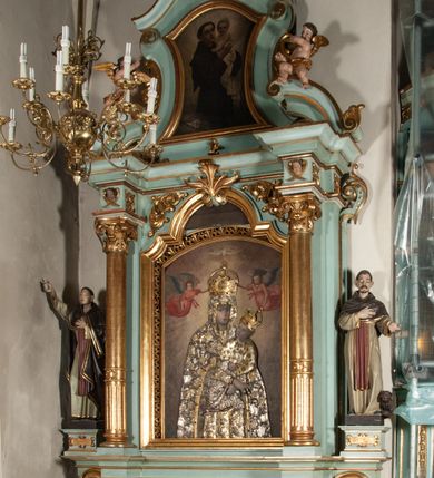 Zdjęcie nr 1: Nastawa architektoniczna, jednoosiowa, jednokondygnacyjna ze zwieńczeniem. Ołtarz drewniany, prostopadłościenny, z drewnianą mensą, ustawiony na profilowanym cokole. Ścianka frontowa ujęta lizenami z płycinami w partii trzonów z akantem. W polu dwie płyciny o fantazyjnej formie wypełnione stylizowanym ornamentem akantowym, flankujące medalion z monogramem Marii. Ścianki boczne dekorowane płycinami. 
Nastawa na cokole z wyodrębnionymi dwoma prostopadłościanami i dwoma skrajnymi konsolami, dekorowana płycinami ze stylizowanym ornamentem. Retabulum ujęte parą kolumn o trzonach kanelowanych w jednej trzeciej wysokości, podtrzymującymi belkowanie o architrawie i fryzie przerwanym nad polem środkowym. Na belkowaniu fragmenty przerwanego, półkolistego przyczółka z siedzącymi puttami. Niemal całe pole główne wypełnione wnęką w formie stojącego prostokąta zamkniętego łukiem półkolistym nadwieszonym, z uskokiem, w profilowanej ramie, z mniejszym obrazem Matki Boskiej Śnieżnej w osobnej ramie. Na konsolach, po bokach nastawy ustawione figury św. Jacka i bł. Czesława. Zwieńczenie w formie zbliżonej do stojącego prostokąta, ujętego spływami wolutowymi, zamkniętego dwiema stykającymi się wolutami oraz dwiema uskrzydlonymi główkami anielskimi w glorii promienistej. W polu obraz św. Antoniego Padewskiego w formie zbliżonej do zwieńczenia, ujęty profilowaną ramą. Struktura polichromowana w kolorze seledynowym, kolumny, profile i ornamentyka złocone. 
