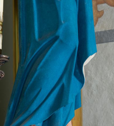 Zdjęcie nr 18: Nastawa architektoniczna, jednoosiowa, jednokondygnacyjna, ustawiona na wysokim cokole. 
Ołtarz drewniany, prostopadłościenny. Na nim tabernakulum z tronem wystawienia. Tabernakulum w formie drewnianej, prostopadłościennej skrzynki, obitej blachą, o wypukłej ściance frontowej, zamkniętej profilowanym gzymsem. Drzwiczki w formie stojącego prostokąta zamkniętego łukiem półkolistym, obwiedzione ramą, z wizerunkiem baranka z krzyżem, leżącego na księdze z pieczęciami, w glorii. Tabernakulum w drewnianej obudowie, wpisane w wysoki cokół, na nim tron wystawienia w formie obrotowej niszy w kształcie stojącego prostokąta, z podwieszoną draperią. Nisza flankowana parą pilastrów, przechodzących w spływy wolutowe, na których siedzą putta. Pilastry dźwigają pełne belkowanie, wyłamane na ich osi, częściowo przerwane przez niszę. Pilastry dekorowane uskrzydlonymi główkami anielskimi oraz snopkiem zboża i kiściami winogron. Cały tron wystawienia dekorowany rocaille&#039;m. 
Nastawa ujęta dwiema parami kolumn o kapitelach kompozytowych, dźwigających pełne belkowanie, wyłamane pomiędzy nimi, przerwane nad polem środkowym. Na belkowaniu fragmenty przerwanego, półkolistego przyczółka, na których leżą putta. Całe pole środkowe wypełnia wnęka w formie stojącego prostokąta zamkniętego łukiem półkolistym, ujęta profilowaną ramą, z figurą Chrystusa Ukrzyżowanego. Nad łukiem wnęki, pomiędzy obłokami, gołębica Ducha Świętego w glorii promienistej. Pomiędzy kolumnami płyciny z uskrzydlonymi główkami anielskimi na obłokach, rocaille oraz figury św.  Jana Ewangelisty i Matki Boskiej na rocaille&#039;owych wspornikach. Kondygnacja ujęta uszami utworzonymi z rocaille&#039;u. Nastawa zwieńczona rzeźbą tronującego Boga Ojca z globem i berłem, pośród obłoków i uskrzydlonych główek anielskich, w glorii promienistej. 
Struktura polichromowana w kolorze błękitnym, kolumny, profile i ornamentyka złocone. 
