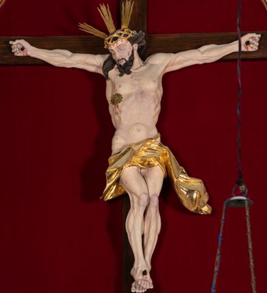 Zdjęcie nr 46: Nastawa architektoniczna, jednoosiowa, jednokondygnacyjna, ustawiona na wysokim cokole. 
Ołtarz drewniany, prostopadłościenny. Na nim tabernakulum z tronem wystawienia. Tabernakulum w formie drewnianej, prostopadłościennej skrzynki, obitej blachą, o wypukłej ściance frontowej, zamkniętej profilowanym gzymsem. Drzwiczki w formie stojącego prostokąta zamkniętego łukiem półkolistym, obwiedzione ramą, z wizerunkiem baranka z krzyżem, leżącego na księdze z pieczęciami, w glorii. Tabernakulum w drewnianej obudowie, wpisane w wysoki cokół, na nim tron wystawienia w formie obrotowej niszy w kształcie stojącego prostokąta, z podwieszoną draperią. Nisza flankowana parą pilastrów, przechodzących w spływy wolutowe, na których siedzą putta. Pilastry dźwigają pełne belkowanie, wyłamane na ich osi, częściowo przerwane przez niszę. Pilastry dekorowane uskrzydlonymi główkami anielskimi oraz snopkiem zboża i kiściami winogron. Cały tron wystawienia dekorowany rocaille'm. 
Nastawa ujęta dwiema parami kolumn o kapitelach kompozytowych, dźwigających pełne belkowanie, wyłamane pomiędzy nimi, przerwane nad polem środkowym. Na belkowaniu fragmenty przerwanego, półkolistego przyczółka, na których leżą putta. Całe pole środkowe wypełnia wnęka w formie stojącego prostokąta zamkniętego łukiem półkolistym, ujęta profilowaną ramą, z figurą Chrystusa Ukrzyżowanego. Nad łukiem wnęki, pomiędzy obłokami, gołębica Ducha Świętego w glorii promienistej. Pomiędzy kolumnami płyciny z uskrzydlonymi główkami anielskimi na obłokach, rocaille oraz figury św.  Jana Ewangelisty i Matki Boskiej na rocaille'owych wspornikach. Kondygnacja ujęta uszami utworzonymi z rocaille'u. Nastawa zwieńczona rzeźbą tronującego Boga Ojca z globem i berłem, pośród obłoków i uskrzydlonych główek anielskich, w glorii promienistej. 
Struktura polichromowana w kolorze błękitnym, kolumny, profile i ornamentyka złocone. 
