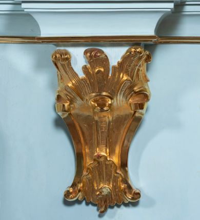 Zdjęcie nr 37: Nastawa architektoniczna, jednoosiowa, jednokondygnacyjna, ustawiona na wysokim cokole. 
Ołtarz drewniany, prostopadłościenny. Na nim tabernakulum z tronem wystawienia. Tabernakulum w formie drewnianej, prostopadłościennej skrzynki, obitej blachą, o wypukłej ściance frontowej, zamkniętej profilowanym gzymsem. Drzwiczki w formie stojącego prostokąta zamkniętego łukiem półkolistym, obwiedzione ramą, z wizerunkiem baranka z krzyżem, leżącego na księdze z pieczęciami, w glorii. Tabernakulum w drewnianej obudowie, wpisane w wysoki cokół, na nim tron wystawienia w formie obrotowej niszy w kształcie stojącego prostokąta, z podwieszoną draperią. Nisza flankowana parą pilastrów, przechodzących w spływy wolutowe, na których siedzą putta. Pilastry dźwigają pełne belkowanie, wyłamane na ich osi, częściowo przerwane przez niszę. Pilastry dekorowane uskrzydlonymi główkami anielskimi oraz snopkiem zboża i kiściami winogron. Cały tron wystawienia dekorowany rocaille&#039;m. 
Nastawa ujęta dwiema parami kolumn o kapitelach kompozytowych, dźwigających pełne belkowanie, wyłamane pomiędzy nimi, przerwane nad polem środkowym. Na belkowaniu fragmenty przerwanego, półkolistego przyczółka, na których leżą putta. Całe pole środkowe wypełnia wnęka w formie stojącego prostokąta zamkniętego łukiem półkolistym, ujęta profilowaną ramą, z figurą Chrystusa Ukrzyżowanego. Nad łukiem wnęki, pomiędzy obłokami, gołębica Ducha Świętego w glorii promienistej. Pomiędzy kolumnami płyciny z uskrzydlonymi główkami anielskimi na obłokach, rocaille oraz figury św.  Jana Ewangelisty i Matki Boskiej na rocaille&#039;owych wspornikach. Kondygnacja ujęta uszami utworzonymi z rocaille&#039;u. Nastawa zwieńczona rzeźbą tronującego Boga Ojca z globem i berłem, pośród obłoków i uskrzydlonych główek anielskich, w glorii promienistej. 
Struktura polichromowana w kolorze błękitnym, kolumny, profile i ornamentyka złocone. 
