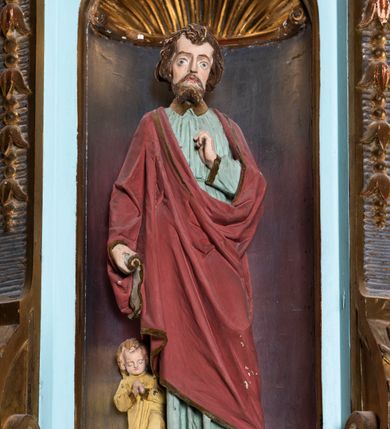 Zdjęcie nr 3: Kosz ambony na planie ośmioboku z szyszką i wolutami u podstawy. Ścianki kosza ujęte pilastrami z karbowaną wstęgą i kampanulami, zakończone od dołu wolutami z motywem liścia akantu oraz wolutą pod kapitelami. W czterech ścianach nisze ze złotymi konchami. W niszach rzeźby czterech ewangelistów z atrybutami. Ponad nimi motywy ornamentalne rocaille z różyczką pośrodku. Na zaplecku tablice Dekalogu na obłoku na tle glorii promienistej. Ujęte w prostokątną ramę zwieńczoną łukiem wklęsło-wypukłym. Baldachim ośmioboczny z podwieszoną glorią i gołębicą, fryz z motywami rocaille&#039;ów i krzyży, wyłamany gzyms. W zwieńczeniu koncentrycznie schodzące się woluty. Ambona polichromowana na kolor seledynowy, detale złocone, postacie w różnobarwnych szatach, partie ciała potraktowane naturalistycznie. 