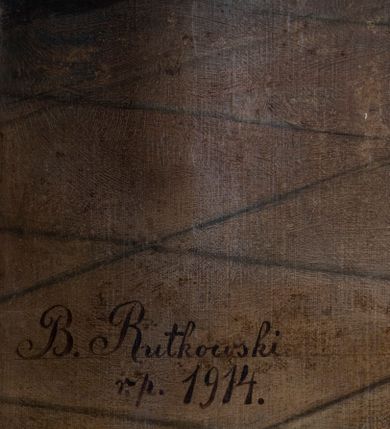 Zdjęcie nr 4: Obraz w formie stojącego prostokąta zamkniętego łukiem odcinkowym, z przedstawieniem Świętej Rodziny w pracowni stolarskiej. W centrum, na pierwszym planie św. Józef ukazany w pozycji stojącej, frontalnie, w kontrapoście, lewą ręką podtrzymuje Dzieciątko, w prawej, wyciągniętej w bok trzyma gałązkę lilii. Twarz ma szczupłą, o starczych rysach, dużych, migdałowatych oczach w ciemnej oprawie, garbatym nosie i wąskich ustach; okoloną gęstą, siwą brodą i krótkimi włosami. Ubrany jest w jasnofioletową, luźną tunikę oraz żółty płaszcz zarzucony na ramiona i z przodu postaci, zapięty pod szyją. Dzieciątko w pozycji siedzącej, zwrócone w trzech czwartych w prawo, w lewej, opuszczonej ręce trzyma krzyżyk, prawą unosi w geście błogosławieństwa. Twarz ma pełną, o dużych, migdałowatych oczach, małym nosie i pełnych ustach; okoloną jasnymi, kręconymi włosami. Ubrane jest w białą, luźną i długą tunikę. W lewej części obrazu, na drugim planie Maria ukazana w pozycji siedzącej, zwrócona w trzech czwartych w lewo, z uniesioną prawą ręką, w którą trzyma igłę z nitką. Twarz ma owalną, o młodzieńczych rysach, dużych oczach, prostym nosie i pełnych ustach, okoloną włosami ukrytymi pod welonem. Ubrana jest w jasnoczerwoną suknię, przepasaną w talii, niebieski płaszcz narzucony na kolana, wokół głowy i szyi ma biały welon, na kolanach zaś białą tkaninę, którą szyje. Postacie ukazane we wnętrzu pracowni, z podłogą wyłożoną kamiennymi płytami i jasnobrązowymi ścianami, w prawej części obrazu ukazany drewniany stół przy którym znajdują się narzędzia stolarskie. W lewym dolnym rogu sygnatura „B(olesław) Rutkowski / r(oku) p(ańskiego) 1914”. 







