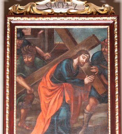 Zdjęcie nr 9: Stacje drogi krzyżowej zawieszone na ścianach bocznych nawy głównej. Obrazy w kształcie stojących prostokątów. W zwieńczeniu w kartuszu oplecionym rzeźbionymi liśćmi akantu malowane nazwy stacji, zapisane „STACYA I / STACYA II [...]”. U góry zakończone krzyżykiem łacińskim. Obrazy ujęte profilowaną ramą, zdobioną kimationem.  Kolorystyka żywa, z dominacją czerwieni i błękitu, plan dalszy rozmyty. Rama polichromowana na bordowo, profilowania i ornamentyka złocone, detale srebrzone.
