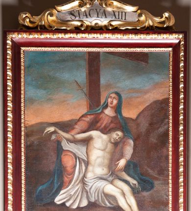 Zdjęcie nr 5: Stacje drogi krzyżowej zawieszone na ścianach bocznych nawy głównej. Obrazy w kształcie stojących prostokątów. W zwieńczeniu w kartuszu oplecionym rzeźbionymi liśćmi akantu malowane nazwy stacji, zapisane „STACYA I / STACYA II [...]”. U góry zakończone krzyżykiem łacińskim. Obrazy ujęte profilowaną ramą, zdobioną kimationem.  Kolorystyka żywa, z dominacją czerwieni i błękitu, plan dalszy rozmyty. Rama polichromowana na bordowo, profilowania i ornamentyka złocone, detale srebrzone.
