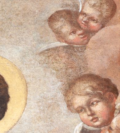 Zdjęcie nr 6: Obraz w formie stojącego prostokąta zamkniętego łukiem półkolistym z przedstawieniem Matki Boskiej Śnieżnej. W centrum kompozycji została ukazana Matka Boska z Dzieciątkiem w ujęciu do kolan, frontalnie. Maria oburącz podtrzymuje siedzące na jej lewym przedramieniu Dzieciątko, a w lewej dłoni trzyma białą chusteczkę. Twarz Marii pełna o delikatnie zarysowanych oczach i długim, prostym nosie oraz małych ustach. Ubrana jest w czerwoną suknię oraz ciemnogranatowy płaszcz zarzucony na głowę i ramiona ze złotą lamówką i gwiazdą na prawym ramieniu. Dzieciątko zwrócone jest trzy czwarte w prawo, głowę delikatnie unosi ku górze w stronę Matki. W lewej ręce trzyma zamkniętą księgą w czerwonej oprawie, a prawą błogosławi. Twarz o dziecięcych rysach z zarumienionymi policzkami. Włosy krótkie, jasne i kędzierzawe. Ubrane jest w białą sukienkę oraz sandały. Oboje wokół głów mają złote i koliste nimby. Nad głową Matki Boskiej znajduje się para aniołków, które podtrzymują zamkniętą koronę. Całość ukazana jest na tle obłoków, po bokach są uskrzydlone główki aniołków. Rama drewniana, profilowana i złocona.