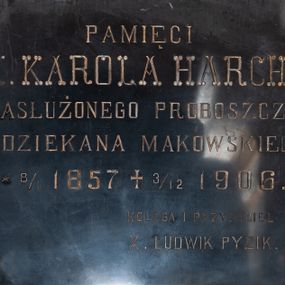 Zdjęcie nr 1: Tablica w kształcie leżącego prostokąta ozdobiona rozetami w narożach. W polu inskrypcja „PAMIĘCI / X(IĘDZA) KAROLA HARCHE / ZASŁUŻONEGO PROBOSZCZA / I DZIEKANA MAKOWSKIEGO / * 8/1 1857 † 3/12 1906. / KOLEGA I PRZYJACIEL / X(IĄDZ) LUDWIK PYZIK.”