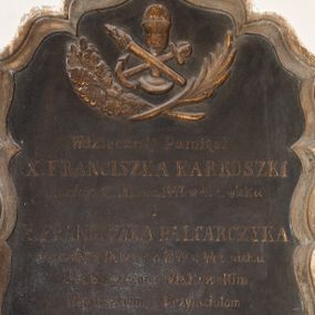 Zdjęcie nr 1: Tablica w formie stojącego prostokąta ujęta w ramę o fantazyjnym zarysie, zwieńczona krzyżem. W górnej części odlany kielich z hostią ze skrzyżowanymi kotwicą i pochodnią, ujęte gałązkami palmy i mirtu. W polu złocona inskrypcja „Wdzięcznej Pamięci / X(IĘDZA) FRANCISZKA KARKOSZKI / zmarłego 26.  Marca 1847 w 41 z(ycia) wieku / i / X(IĘDZA) FRANCISZKA BALCARCZYKA / zmarłego 18. Czerwca 1849 w 44 z(ycia) wieku / Proboszczom Makowskim / Współbraciom i Przyjaciołom / ten kamień położył / X(IĄDZ) FRANCISZEK XAWERY CIESIELSKI / Pleban w Suchy.” 

