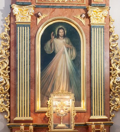 Zdjęcie nr 1: Ołtarz przyścienny, architektoniczny, jednokondygnacyjny ze zwieńczeniem. Mensa prostopadłościenna, ustawiona na jednostopniowym podwyższeniu. Antepedium ujęte profilowaną, prostokątną płyciną, obwiedzioną złoconą ramą. Tabernakulum w formie prostopadłościennej skrzynki, flankowane po bokach rzeźbionymi uszami utworzonymi z uskrzydlonych główek aniołków i wolut, zamknięte profilowanym gzymsem. Drzwiczki w formie kwadratowej płyciny, obwiedzionej pasem cekinów, z równoramiennym krzyżem i medalionem z wyobrażeniem pelikana karmiącego pisklęta w centrum. Tron wystawienia w formie prostopadłościennej, szklanej gabloty, dekorowanej wzdłuż naroży stylizowanymi, wysuszonymi liśćmi akantu. Nastawa ujęta parą pilastrów na cokołach, o kanelowanych trzonach i kapitelach kompozytowych dźwigających niepełne belkowanie z wydatnym gzymsem, wyłamanym w ich partii. W polu głównym obraz „Jezu ufam Tobie” w formie stojącego prostokąta zamkniętego łukiem półkolistym w profilowanej ramie. Zwieńczenie w kształcie stojącego prostokąta zamkniętego gzymsem o łuku nadwieszonym. W polu obraz ze św. Faustyną w formie powtarzającej linie zwieńczenia. Cokoły dekorowane płycinami ze stylizowanymi, wysuszonymi i spiralnie skręconymi liśćmi akantu. W przyłuczach w polu środkowym uskrzydlone główki anielskie. Fryz dekorowany płycinami z ornamentem wstęgowo-cęgowym oraz rozetami. Kondygnacja i zwieńczenie ujęte uszami utworzonymi z suchego akantu. 
Ołtarz marmoryzowany w kolorystyce różowo-pomarańczowej z detalami architektonicznymi marmoryzowanymi w kolorystyce czarnego marmuru; detale i ornamentyka złocone i srebrzone.