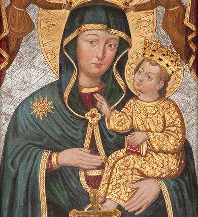 Zdjęcie nr 1: Obraz w formie stojącego prostokąta, w złoconej ramie. W centrum kompozycji ukazana Matka Boska z Dzieciątkiem (Hodegetria) ujęta frontalnie, w półpostaci. Głowa zwrócona delikatnie w lewo; na swoim lewym przedramieniu podtrzymuje siedzące Dzieciątko; prawą dłonią wskazuje na Jezusa. Twarz pociągła, rumiana, o delikatnie zarysowanych oczach i brwiach, prostym nosie wydobytym światłocieniem oraz karminowych, niewielkich ustach. Maria ubrana jest w bordową suknię ze złotą lamówką oraz ciemnoniebieski płaszcz podbity zielenią, z gwiazdą z monogramem IHS na prawym ramieniu; spięty na piersi złotą zaponą. Dzieciątko ubrane w złoconą tunikę, unosi głowę lekko ku górze, zwracając się ku Marii. Swoją prawą ręką błogosławi; lewą podtrzymuje opartą na kolanach księgę. Obie postaci ukazane są w aplikowanych, kameryzowanych koronach. Maria i Dzieciątko mają wokół głów tłoczone, koliste, złocone nimby. W górnej części kompozycji bordowa kotara ze złoconą lamówką, podtrzymywana przez anioły jednocześnie trzymające w dłoniach koronę nad głową Marii. Anioły ubrane w złocone tuniki. Tło jednolite, srebrzone, wytłaczane w motyw ukośnej kraty wypełnionej rozetami. Rama drewniana, profilowana.