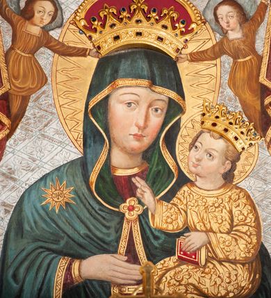 Zdjęcie nr 2: Obraz w formie stojącego prostokąta, w złoconej ramie. W centrum kompozycji ukazana Matka Boska z Dzieciątkiem (Hodegetria) ujęta frontalnie, w półpostaci. Głowa zwrócona delikatnie w lewo; na swoim lewym przedramieniu podtrzymuje siedzące Dzieciątko; prawą dłonią wskazuje na Jezusa. Twarz pociągła, rumiana, o delikatnie zarysowanych oczach i brwiach, prostym nosie wydobytym światłocieniem oraz karminowych, niewielkich ustach. Maria ubrana jest w bordową suknię ze złotą lamówką oraz ciemnoniebieski płaszcz podbity zielenią, z gwiazdą z monogramem IHS na prawym ramieniu; spięty na piersi złotą zaponą. Dzieciątko ubrane w złoconą tunikę, unosi głowę lekko ku górze, zwracając się ku Marii. Swoją prawą ręką błogosławi; lewą podtrzymuje opartą na kolanach księgę. Obie postaci ukazane są w aplikowanych, kameryzowanych koronach. Maria i Dzieciątko mają wokół głów tłoczone, koliste, złocone nimby. W górnej części kompozycji bordowa kotara ze złoconą lamówką, podtrzymywana przez anioły jednocześnie trzymające w dłoniach koronę nad głową Marii. Anioły ubrane w złocone tuniki. Tło jednolite, srebrzone, wytłaczane w motyw ukośnej kraty wypełnionej rozetami. Rama drewniana, profilowana.