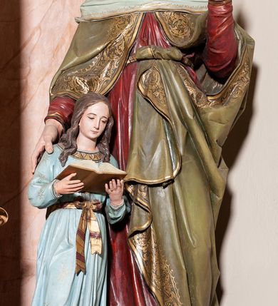 Zdjęcie nr 9: Ołtarz przyścienny, architektoniczny, jednoosiowy, jednokondygnacyjny ze zwieńczeniem. Mensa ołtarzowa skrzyniowa, prostopadłościenna z portatylem w formie kamiennej płytki. Antepedium współczesne, ujęte profilowaną ramą zdobioną żłobionym wałkiem, obite blachą miedzianą, na której odlewana, aplikowana dekoracja przedstawiająca w centrum Baranka Bożego w glorii promienistej z obłokami, po bokach dwie klęczące postacie kobiece, symbole ewangelistów oraz motywy kwiatowe. Tabernakulum w formie prostopadłościennej skrzynki, ustawione na cokole, zamknięte profilowanym gzymsem. Drzwiczki w kształcie stojącego prostokąta z malowanymi czterema scenami z życia Chrystusa. Narożniki obwiedzione złotymi listwami. Nastawa ołtarzowa umieszczona na podwójnym cokole, flankowana dwiema kolumnami, kanelowanymi od jednej czwartej wysokości o kapitelach kompozytowych, dźwigających pełne, wyłamane belkowanie oraz imposty ustawione pod kątem, na których znajduje się para puttów. Po zewnętrznej stronie kolumn cokoły z figurami św. Józefa z Dzieciątkiem po lewej i św. Anny z Marią po prawej. Pole środkowe w formie niszy w kształcie stojącego prostokąta o wciętych górnych narożach z pełnoplastyczną figurą Najświętszego Serca Jezusa. Zwieńczenie w formie promienistej glorii, z otoczonym obłokami medalionem w środku z gorejącym sercem. Cokoły figur i kolumn dekorowane płycinami z esowato wygiętym ornamentem roślinnym. Gzyms impostów zdobiony ornamentem roślinnym, w partii fryzu rzeźbiona uskrzydlona główka anielska. Rama w polu środkowym dekorowana płaskorzeźbionym ornamentem roślinnym. Struktura marmoryzowana w odcieniu różowo-błękitnym, detale architektoniczne polichromowane na niebiesko i czerwono, ornamentyka i profilowania pozłacane i posrebrzane.