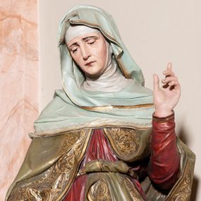Zdjęcie nr 1: Rzeźby pełne, ustawione na postumencie. Święta Anna ukazana frontalnie, w delikatnym kontrapoście z lewą nogą ugiętą w kolanie, lewą rękę unosząca w geście pouczenia, prawą obejmująca małą Marię. Twarz podłużna, z małymi ustami, długim nosem i przymkniętymi oczami. Ubrana jest w czerwoną suknię z długimi rękawami, oliwkowozielony płaszcz, zdobiony na brzegach stylizowaną wicią roślinną, biały welon na głowie i niebieską chustę ozdobioną złotą lamówką, na stopach ma założone buty. Płaszcz i suknie przewiązane są w talii paskiem, jedna poła płaszcza zawinięta za pasek. Maria delikatnie przechylona na św. Annę z otwartą księgą w dłoniach i głową pochyloną do przodu. Twarz owalna z drobnymi ustami, prostym nosem i przymkniętymi oczami. Włosy długie, bujne, ciemnobrązowe, opadające na plecy i piersi. Ubrana jest w błękitną suknię, przewiązaną szarfą, u szyi zdobioną złotą lamówką, a na powierzchni złotymi gwiazdami. Polichromia w odsłoniętych partiach ciała naturalistyczna, detale stroju złocone. 

