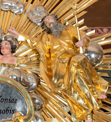 Zdjęcie nr 9: Nastawa ołtarzowa jednoosiowa, jednokondygnacyjna ze zwieńczeniem, na podwójnym cokole. W partii cokołu prostokątne płyciny, z których wewnętrzne są wypełnione wotami.  Mensa drewniana, wklęsło-wypukła. Kondygnacja nastawy ujęta szerokimi pilastrami o kapitelach zdobionych liśćmi akantu ustawionymi skośnie oraz stojącą przed nimi parą kolumn. Podpory dźwigają fragmenty pełnego belkowania wyłamanego na ich osiach; przerwanego nad polem środkowym. Kolumny podtrzymują przerwany przyczółek, na którym ustawiono fragmenty dekoracji rokokowej. Podpory ustawione zostały na profilowanych cokołach, po ich wewnętrznych stronach figury św. Piotra po lewej i św. Pawła po prawej stronie. W polu środkowym obraz z przedstawieniem Matki Boskiej Częstochowskiej w profilowanej ramie w kształcie stojącego prostokąta Nad nia kartusz z napisem „Regina Poloniae / ora pro nobis”. Kondygnacje ujmują uszaki z płomienistego rocaille’a.  Zwieńczenie tworzy rzeźbiarska grupa Trójcy świętej na obłokach, między którymi unoszą się uskrzydlone główki anielskie. Struktura polichromowana na kremowo, kolumny złocone, detale, profile i ornamenty złocone i srebrzone. 