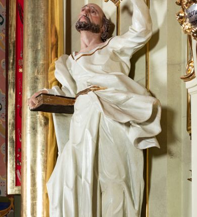 Zdjęcie nr 26: Nastawa ołtarzowa jednoosiowa, jednokondygnacyjna ze zwieńczeniem, na podwójnym cokole. W partii cokołu prostokątne płyciny, z których wewnętrzne są wypełnione wotami.  Mensa drewniana, wklęsło-wypukła. Kondygnacja nastawy ujęta szerokimi pilastrami o kapitelach zdobionych liśćmi akantu ustawionymi skośnie oraz stojącą przed nimi parą kolumn. Podpory dźwigają fragmenty pełnego belkowania wyłamanego na ich osiach; przerwanego nad polem środkowym. Kolumny podtrzymują przerwany przyczółek, na którym ustawiono fragmenty dekoracji rokokowej. Podpory ustawione zostały na profilowanych cokołach, po ich wewnętrznych stronach figury św. Piotra po lewej i św. Pawła po prawej stronie. W polu środkowym obraz z przedstawieniem Matki Boskiej Częstochowskiej w profilowanej ramie w kształcie stojącego prostokąta Nad nia kartusz z napisem „Regina Poloniae / ora pro nobis”. Kondygnacje ujmują uszaki z płomienistego rocaille’a.  Zwieńczenie tworzy rzeźbiarska grupa Trójcy świętej na obłokach, między którymi unoszą się uskrzydlone główki anielskie. Struktura polichromowana na kremowo, kolumny złocone, detale, profile i ornamenty złocone i srebrzone. 