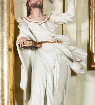 Zdjęcie nr 28: Nastawa ołtarzowa jednoosiowa, jednokondygnacyjna ze zwieńczeniem, na podwójnym cokole. W partii cokołu prostokątne płyciny, z których wewnętrzne są wypełnione wotami.  Mensa drewniana, wklęsło-wypukła. Kondygnacja nastawy ujęta szerokimi pilastrami o kapitelach zdobionych liśćmi akantu ustawionymi skośnie oraz stojącą przed nimi parą kolumn. Podpory dźwigają fragmenty pełnego belkowania wyłamanego na ich osiach; przerwanego nad polem środkowym. Kolumny podtrzymują przerwany przyczółek, na którym ustawiono fragmenty dekoracji rokokowej. Podpory ustawione zostały na profilowanych cokołach, po ich wewnętrznych stronach figury św. Piotra po lewej i św. Pawła po prawej stronie. W polu środkowym obraz z przedstawieniem Matki Boskiej Częstochowskiej w profilowanej ramie w kształcie stojącego prostokąta Nad nia kartusz z napisem „Regina Poloniae / ora pro nobis”. Kondygnacje ujmują uszaki z płomienistego rocaille’a.  Zwieńczenie tworzy rzeźbiarska grupa Trójcy świętej na obłokach, między którymi unoszą się uskrzydlone główki anielskie. Struktura polichromowana na kremowo, kolumny złocone, detale, profile i ornamenty złocone i srebrzone. 