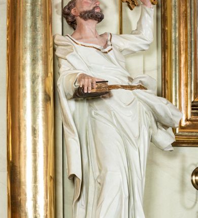 Zdjęcie nr 29: Nastawa ołtarzowa jednoosiowa, jednokondygnacyjna ze zwieńczeniem, na podwójnym cokole. W partii cokołu prostokątne płyciny, z których wewnętrzne są wypełnione wotami.  Mensa drewniana, wklęsło-wypukła. Kondygnacja nastawy ujęta szerokimi pilastrami o kapitelach zdobionych liśćmi akantu ustawionymi skośnie oraz stojącą przed nimi parą kolumn. Podpory dźwigają fragmenty pełnego belkowania wyłamanego na ich osiach; przerwanego nad polem środkowym. Kolumny podtrzymują przerwany przyczółek, na którym ustawiono fragmenty dekoracji rokokowej. Podpory ustawione zostały na profilowanych cokołach, po ich wewnętrznych stronach figury św. Piotra po lewej i św. Pawła po prawej stronie. W polu środkowym obraz z przedstawieniem Matki Boskiej Częstochowskiej w profilowanej ramie w kształcie stojącego prostokąta Nad nia kartusz z napisem „Regina Poloniae / ora pro nobis”. Kondygnacje ujmują uszaki z płomienistego rocaille’a.  Zwieńczenie tworzy rzeźbiarska grupa Trójcy świętej na obłokach, między którymi unoszą się uskrzydlone główki anielskie. Struktura polichromowana na kremowo, kolumny złocone, detale, profile i ornamenty złocone i srebrzone. 