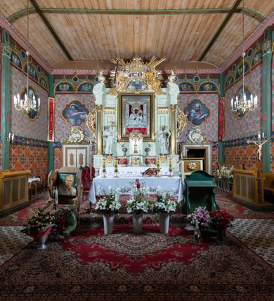 Zdjęcie nr 2: Nastawa ołtarzowa jednoosiowa, jednokondygnacyjna ze zwieńczeniem, na podwójnym cokole. W partii cokołu prostokątne płyciny, z których wewnętrzne są wypełnione wotami.  Mensa drewniana, wklęsło-wypukła. Kondygnacja nastawy ujęta szerokimi pilastrami o kapitelach zdobionych liśćmi akantu ustawionymi skośnie oraz stojącą przed nimi parą kolumn. Podpory dźwigają fragmenty pełnego belkowania wyłamanego na ich osiach; przerwanego nad polem środkowym. Kolumny podtrzymują przerwany przyczółek, na którym ustawiono fragmenty dekoracji rokokowej. Podpory ustawione zostały na profilowanych cokołach, po ich wewnętrznych stronach figury św. Piotra po lewej i św. Pawła po prawej stronie. W polu środkowym obraz z przedstawieniem Matki Boskiej Częstochowskiej w profilowanej ramie w kształcie stojącego prostokąta Nad nia kartusz z napisem „Regina Poloniae / ora pro nobis”. Kondygnacje ujmują uszaki z płomienistego rocaille’a.  Zwieńczenie tworzy rzeźbiarska grupa Trójcy świętej na obłokach, między którymi unoszą się uskrzydlone główki anielskie. Struktura polichromowana na kremowo, kolumny złocone, detale, profile i ornamenty złocone i srebrzone. 