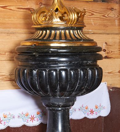 Zdjęcie nr 1: Podstawa utworzona z cylindrycznej dolnej i prostopadłościennej górnej części, z trzonem w typie gruszkowatym podtrzymującym czarę w formie spłaszczonej kuli z puklami. Pokrywa drewniana, w kształcie korony z czterema kabłąkami, zwieńczona kulą z gołębicą Ducha Świętego.