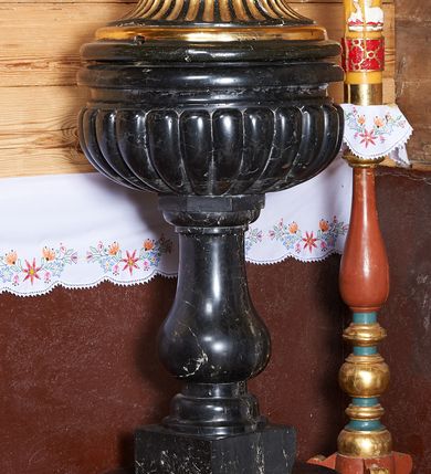 Zdjęcie nr 2: Podstawa utworzona z cylindrycznej dolnej i prostopadłościennej górnej części, z trzonem w typie gruszkowatym podtrzymującym czarę w formie spłaszczonej kuli z puklami. Pokrywa drewniana, w kształcie korony z czterema kabłąkami, zwieńczona kulą z gołębicą Ducha Świętego.