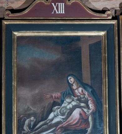 Zdjęcie nr 5: Obrazy w kształcie stojącego prostokąta z przedstawieniem Stacji Drogi Krzyżowej w profilowanych ramach, ujęte od góry i dołu uszami o fantazyjnym wykroju, zwieńczone krzyżykiem łacińskim. Sceny wielofiguralne, na większości kompozycji pośrodku ukazany Chrystus ubrany w długą, jasnobłękitną suknię oraz czerwony płaszcz, na głowie korona cierniowa. Twarz owalna, okolona krótkim zarostem i włosami opadającymi na ramiona. W tle sumaryczny, skalisty pejzaż z elementami architektury.