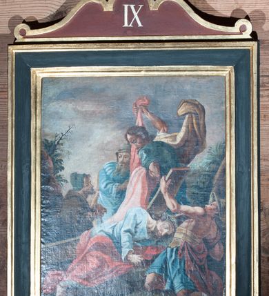 Zdjęcie nr 13: Obrazy w kształcie stojącego prostokąta z przedstawieniem Stacji Drogi Krzyżowej w profilowanych ramach, ujęte od góry i dołu uszami o fantazyjnym wykroju, zwieńczone krzyżykiem łacińskim. Sceny wielofiguralne, na większości kompozycji pośrodku ukazany Chrystus ubrany w długą, jasnobłękitną suknię oraz czerwony płaszcz, na głowie korona cierniowa. Twarz owalna, okolona krótkim zarostem i włosami opadającymi na ramiona. W tle sumaryczny, skalisty pejzaż z elementami architektury.