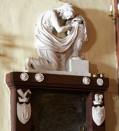 Zdjęcie nr 1: Wmurowany w ścianę kościoła nagrobek, na wysokim postumencie, z tablicą w kształcie leżącego prostokąta z czterema metalowymi ćwiekami w kształcie rozet, w szerokiej ramie z stiukowymi herbami Nowina i Bogoria na bokach i profilowanym gzymsem z czterema stiukowymi rozetami. Ponad gzymsem ukazana z prawego profilu klęcząca i wsparta na urnie kobieta, ubrana w togę i płaszcz zarzucony na głowę, plecy i częściowo zakrywający urnę, na której kobieta wspiera ręce i głowę. Twarz pełna, o delikatnych rysach i zamkniętych oczach. Włosy sięgające ramion, o gęstych, kręconych puklach. Urna w typie amfory greckiej zdobiona dołem szerokimi liśćmi i pięciopłatkowymi kwiatami, górą fryzem z liśćmi akantu. Na tablicy inskrypcja: &quot;D(eo) O(ptimo) M(aximo) / Józefowi i Teressie Skotnickich / KONOPKOM. / Łowczym Sanockim / Rodzicom Dobrodziejom Naszym. / Teressie w dniu 15. Grudnia 1801. a Józefowi / d(nia) 27. Września 1811. R(oku) zmarłym / Pomnik kładziemy&quot;. 