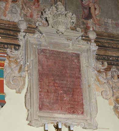 Zdjęcie nr 1: Tablica w kształcie stojącego prostokąta, w ozdobnej, uszatej ramie, podtrzymywana po bokach przez dwie, płaskorzeźbione postacie, zwieńczona kartuszem z herbami: Dołęga, Śreniawa i Radwan. W polu marmurowa prostokątna płyta z majuskułową inskrypcją w języku polskim, częściowo nieczytelną: BÓG W TRÓJCY JEDYNEMU NASWIETSZY PANNIE / MIESZKANCZOM WSZYSTKIM NIEBA TAKŻE S. ANNIE / NA CZESC I CHWALE (...) ZBUDOWAĆ KAZAŁ  / KATARZINA KUCHARsKA CHCĄC BY SIĘ TU CHWAŁA / PAŃSKA SZERZEŁA ZAWSZE PÓKI LUDZKIE PLEMIĘ  / OSIADAĆ BĘDZIE (...) WSZYSTKO RODNĄ ZIEMIĘ  / A TY CZO WLADASZ WSZYSTKIMMNIE SPOTOMSTWEM MOIM / WRODZONA KATARZINA SPRZIBYSŁAWIC / KUCHARZSKA VRODZONEGO STANISŁAWA KUCHARSKIEGO SKUCHAR ZWOIEWODZTWA / PŁOCKIEGO POZOSTAWIŁA MAŁŻONKA SKTÓRYM / SPŁODZIEŁA SYNOW WRODZONYCH JANA PIOTRA JACKA / NA CZEŚĆ I NA CHWAŁE PANU BOGU WSZECHMOGĄCEMU / NAJWIĘTSZEJ PANNIE MARYIEI I S. ANNIE PATRONCE TEJ (...) Z GRUNTU ZMUROWACZ DAŁA / FUNDOWAŁA CHCĄC ABY JEJ CIAŁO NAMILSZEGO / MAŁŻONKA IJ POTOMKÓW (...) DNIA OSTATNIEGO OCZEKIWAŁO / ROKU PAŃSKIEGO 1622.