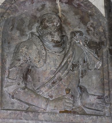 Zdjęcie nr 14: Epitafium w oprawie architektonicznej w formie aedikuli z płaskorzeźbioną półpostacią zmarłego oraz tablicą z inskrypcją; ujęte zdwojonymi pilastrami o kapitelach korynckich; trzony do połowy wysokości dekorowane płycinami, powyżej festonami i chwostami. Podpory dźwigają imposty zakończone cokołami z kulami. Zewnętrzne pilastry z wolutą w połowie wysokości. U spodu dwie woluty dekorowane perełkowaniem i kwiatami z szyszką w formie cokołu z kulą. Ponad niszą płyta ujęta wolutami. Całość zwieńczona kartuszem z herbem Odrowąż (?) flankowanym wolutami z labrami w postaci bujnej dekoracji roślinnej oraz płaskorzeźbiona figurą Chrystusa Zmartwychwstałego. O MORS CIELDELLIS? NVLLUM EST LIBIDIMINE DIGNA / NAM NVLLI PARCIT NVLLAQ(VE) DONA IVVANT.