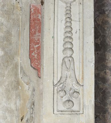 Zdjęcie nr 11: Epitafium w oprawie architektonicznej w formie aedikuli z płaskorzeźbioną półpostacią zmarłego oraz tablicą z inskrypcją; ujęte zdwojonymi pilastrami o kapitelach korynckich; trzony do połowy wysokości dekorowane płycinami, powyżej festonami i chwostami. Podpory dźwigają imposty zakończone cokołami z kulami. Zewnętrzne pilastry z wolutą w połowie wysokości. U spodu dwie woluty dekorowane perełkowaniem i kwiatami z szyszką w formie cokołu z kulą. Ponad niszą płyta ujęta wolutami. Całość zwieńczona kartuszem z herbem Odrowąż (?) flankowanym wolutami z labrami w postaci bujnej dekoracji roślinnej oraz płaskorzeźbiona figurą Chrystusa Zmartwychwstałego. O MORS CIELDELLIS? NVLLUM EST LIBIDIMINE DIGNA / NAM NVLLI PARCIT NVLLAQ(VE) DONA IVVANT.