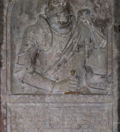 Zdjęcie nr 12: Epitafium w oprawie architektonicznej w formie aedikuli z płaskorzeźbioną półpostacią zmarłego oraz tablicą z inskrypcją; ujęte zdwojonymi pilastrami o kapitelach korynckich; trzony do połowy wysokości dekorowane płycinami, powyżej festonami i chwostami. Podpory dźwigają imposty zakończone cokołami z kulami. Zewnętrzne pilastry z wolutą w połowie wysokości. U spodu dwie woluty dekorowane perełkowaniem i kwiatami z szyszką w formie cokołu z kulą. Ponad niszą płyta ujęta wolutami. Całość zwieńczona kartuszem z herbem Odrowąż (?) flankowanym wolutami z labrami w postaci bujnej dekoracji roślinnej oraz płaskorzeźbiona figurą Chrystusa Zmartwychwstałego. O MORS CIELDELLIS? NVLLUM EST LIBIDIMINE DIGNA / NAM NVLLI PARCIT NVLLAQ(VE) DONA IVVANT.