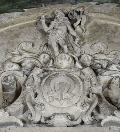 Zdjęcie nr 6: Epitafium w oprawie architektonicznej w formie aedikuli z płaskorzeźbioną półpostacią zmarłego oraz tablicą z inskrypcją; ujęte zdwojonymi pilastrami o kapitelach korynckich; trzony do połowy wysokości dekorowane płycinami, powyżej festonami i chwostami. Podpory dźwigają imposty zakończone cokołami z kulami. Zewnętrzne pilastry z wolutą w połowie wysokości. U spodu dwie woluty dekorowane perełkowaniem i kwiatami z szyszką w formie cokołu z kulą. Ponad niszą płyta ujęta wolutami. Całość zwieńczona kartuszem z herbem Odrowąż (?) flankowanym wolutami z labrami w postaci bujnej dekoracji roślinnej oraz płaskorzeźbiona figurą Chrystusa Zmartwychwstałego. O MORS CIELDELLIS? NVLLUM EST LIBIDIMINE DIGNA / NAM NVLLI PARCIT NVLLAQ(VE) DONA IVVANT.