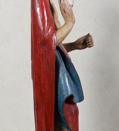 Zdjęcie nr 3: Rzeźba Chrystusa Zmartwychwstałego, pełnoplastyczna, z tyłu opracowana, ustawiona na niskim, okrągłym cokole. Chrystus ukazany w całej postaci, frontalnie, z prawą ręką uniesioną w geście błogosławieństwa, w lewej trzyma chorągiew. Ubrany w czerwony płaszcz z niebieską podszewką, spływający z lewego ramienia, przez przód postaci, na prawe przedramię, tworząc znaczną fałdę misową. Korpus ciała nagi. Twarz podłużna, z lekko rozchylonymi ustami, okolona krótko przystrzyżoną brodą i ciemnobrązowymi włosami opadającymi na plecy. Wokół głowy złoty, kolisty nimb z metalowego pręta. Czerwona chorągiew z tkaniny zawieszona na długim, złotym i drewnianym drzewcu zakończonym krzyżykiem.