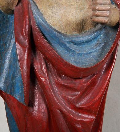 Zdjęcie nr 4: Rzeźba Chrystusa Zmartwychwstałego, pełnoplastyczna, z tyłu opracowana, ustawiona na niskim, okrągłym cokole. Chrystus ukazany w całej postaci, frontalnie, z prawą ręką uniesioną w geście błogosławieństwa, w lewej trzyma chorągiew. Ubrany w czerwony płaszcz z niebieską podszewką, spływający z lewego ramienia, przez przód postaci, na prawe przedramię, tworząc znaczną fałdę misową. Korpus ciała nagi. Twarz podłużna, z lekko rozchylonymi ustami, okolona krótko przystrzyżoną brodą i ciemnobrązowymi włosami opadającymi na plecy. Wokół głowy złoty, kolisty nimb z metalowego pręta. Czerwona chorągiew z tkaniny zawieszona na długim, złotym i drewnianym drzewcu zakończonym krzyżykiem.