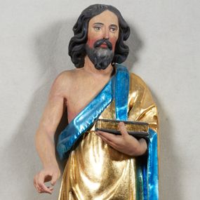 Zdjęcie nr 1: Rzeźba pełnoplastyczna z przedstawieniem Jana Chrzciciela. Święty ukazany frontalnie, w delikatnym kontrapoście, z prawą nogą ugiętą w kolanie, ręce ugięte w łokciach, lewą dłonią podtrzymuje przed sobą księgę, prawa ułożona w geście trzymania niezachowanego atrybutu. Ubrany w krótką szatę (zapewne ze skóry wielbłąda), sięgającą do kolan i odsłaniającą prawe ramię, oraz złoty płaszcz z niebieską podszewką, zarzucony na lewe ramię. Twarz podłużna, okolona ciemną brodą i silnie falowanymi włosami, sięgającymi do ramion i opadającymi na plecy. Karnacja jasna, policzki silnie zarumienione.
