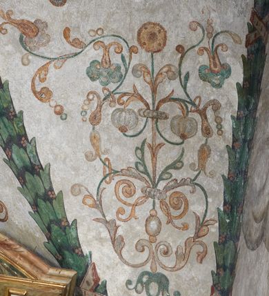Zdjęcie nr 31: Strukturę architektoniczną kaplicy, wzniesionej na rzucie kwadratu ze ściętymi od północy narożami i sklepionej krzyżowo z lunetami spływającymi na wsporniki w kształcie kapiteli jońskich, podkreśla ornament złożony z motywów roślinnych. Szwy sklepienne pokrywa wić z liści i owoców wawrzynu miejscami przewiązana skrzyżowaną wstęgą. Pola sklepienia wypełniają medaliony z przedstawieniami czterech ewangelistów w ramach zdobionych ornamentem okuciowym, dzbany z kwiatami lilii, z uszami o motywach antropomorficznych oraz wici roślinne m. in. z motywami kwiatów lilii, falującymi wstęgami, zwisami z owoców oraz z tkaninami. Na ścianach sceny: Św. Stanisław wskrzeszający Piotrowina, Św. Wojciech, Przemienienie Pańskie na górze Tabor oraz kartusze herbowe. Kolorystyka pastelowa z przewagą zieleni, czerwieni i beżu.