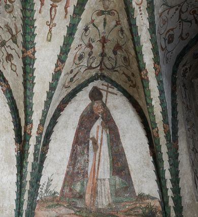 Zdjęcie nr 16: Strukturę architektoniczną kaplicy, wzniesionej na rzucie kwadratu ze ściętymi od północy narożami i sklepionej krzyżowo z lunetami spływającymi na wsporniki w kształcie kapiteli jońskich, podkreśla ornament złożony z motywów roślinnych. Szwy sklepienne pokrywa wić z liści i owoców wawrzynu miejscami przewiązana skrzyżowaną wstęgą. Pola sklepienia wypełniają medaliony z przedstawieniami czterech ewangelistów w ramach zdobionych ornamentem okuciowym, dzbany z kwiatami lilii, z uszami o motywach antropomorficznych oraz wici roślinne m. in. z motywami kwiatów lilii, falującymi wstęgami, zwisami z owoców oraz z tkaninami. Na ścianach sceny: Św. Stanisław wskrzeszający Piotrowina, Św. Wojciech, Przemienienie Pańskie na górze Tabor oraz kartusze herbowe. Kolorystyka pastelowa z przewagą zieleni, czerwieni i beżu.