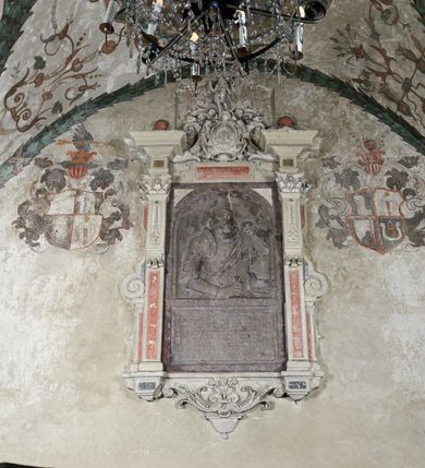 Zdjęcie nr 22: Strukturę architektoniczną kaplicy, wzniesionej na rzucie kwadratu ze ściętymi od północy narożami i sklepionej krzyżowo z lunetami spływającymi na wsporniki w kształcie kapiteli jońskich, podkreśla ornament złożony z motywów roślinnych. Szwy sklepienne pokrywa wić z liści i owoców wawrzynu miejscami przewiązana skrzyżowaną wstęgą. Pola sklepienia wypełniają medaliony z przedstawieniami czterech ewangelistów w ramach zdobionych ornamentem okuciowym, dzbany z kwiatami lilii, z uszami o motywach antropomorficznych oraz wici roślinne m. in. z motywami kwiatów lilii, falującymi wstęgami, zwisami z owoców oraz z tkaninami. Na ścianach sceny: Św. Stanisław wskrzeszający Piotrowina, Św. Wojciech, Przemienienie Pańskie na górze Tabor oraz kartusze herbowe. Kolorystyka pastelowa z przewagą zieleni, czerwieni i beżu.