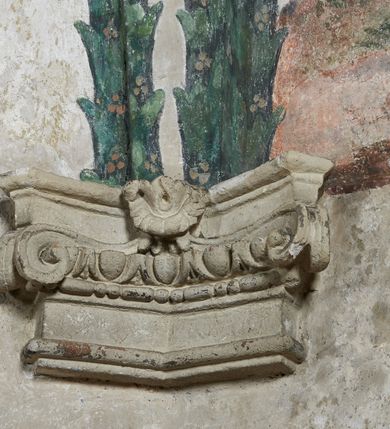 Zdjęcie nr 5: Strukturę architektoniczną kaplicy, wzniesionej na rzucie kwadratu ze ściętymi od północy narożami i sklepionej krzyżowo z lunetami spływającymi na wsporniki w kształcie kapiteli jońskich, podkreśla ornament złożony z motywów roślinnych. Szwy sklepienne pokrywa wić z liści i owoców wawrzynu miejscami przewiązana skrzyżowaną wstęgą. Pola sklepienia wypełniają medaliony z przedstawieniami czterech ewangelistów w ramach zdobionych ornamentem okuciowym, dzbany z kwiatami lilii, z uszami o motywach antropomorficznych oraz wici roślinne m. in. z motywami kwiatów lilii, falującymi wstęgami, zwisami z owoców oraz z tkaninami. Na ścianach sceny: Św. Stanisław wskrzeszający Piotrowina, Św. Wojciech, Przemienienie Pańskie na górze Tabor oraz kartusze herbowe. Kolorystyka pastelowa z przewagą zieleni, czerwieni i beżu.