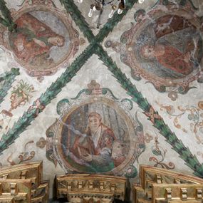 Zdjęcie nr 1: Strukturę architektoniczną kaplicy, wzniesionej na rzucie kwadratu ze ściętymi od północy narożami i sklepionej krzyżowo z lunetami spływającymi na wsporniki w kształcie kapiteli jońskich, podkreśla ornament złożony z motywów roślinnych. Szwy sklepienne pokrywa wić z liści i owoców wawrzynu miejscami przewiązana skrzyżowaną wstęgą. Pola sklepienia wypełniają medaliony z przedstawieniami czterech ewangelistów w ramach zdobionych ornamentem okuciowym, dzbany z kwiatami lilii, z uszami o motywach antropomorficznych oraz wici roślinne m. in. z motywami kwiatów lilii, falującymi wstęgami, zwisami z owoców oraz z tkaninami. Na ścianach sceny: Św. Stanisław wskrzeszający Piotrowina, Św. Wojciech, Przemienienie Pańskie na górze Tabor oraz kartusze herbowe. Kolorystyka pastelowa z przewagą zieleni, czerwieni i beżu.