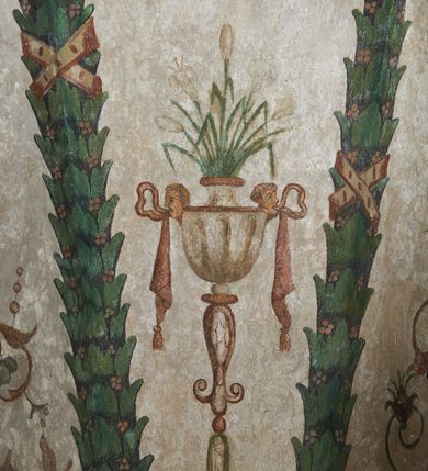 Zdjęcie nr 32: Strukturę architektoniczną kaplicy, wzniesionej na rzucie kwadratu ze ściętymi od północy narożami i sklepionej krzyżowo z lunetami spływającymi na wsporniki w kształcie kapiteli jońskich, podkreśla ornament złożony z motywów roślinnych. Szwy sklepienne pokrywa wić z liści i owoców wawrzynu miejscami przewiązana skrzyżowaną wstęgą. Pola sklepienia wypełniają medaliony z przedstawieniami czterech ewangelistów w ramach zdobionych ornamentem okuciowym, dzbany z kwiatami lilii, z uszami o motywach antropomorficznych oraz wici roślinne m. in. z motywami kwiatów lilii, falującymi wstęgami, zwisami z owoców oraz z tkaninami. Na ścianach sceny: Św. Stanisław wskrzeszający Piotrowina, Św. Wojciech, Przemienienie Pańskie na górze Tabor oraz kartusze herbowe. Kolorystyka pastelowa z przewagą zieleni, czerwieni i beżu.