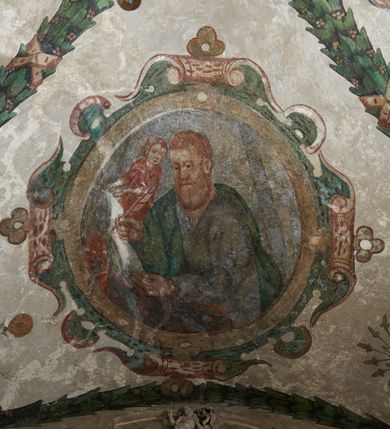 Zdjęcie nr 24: Strukturę architektoniczną kaplicy, wzniesionej na rzucie kwadratu ze ściętymi od północy narożami i sklepionej krzyżowo z lunetami spływającymi na wsporniki w kształcie kapiteli jońskich, podkreśla ornament złożony z motywów roślinnych. Szwy sklepienne pokrywa wić z liści i owoców wawrzynu miejscami przewiązana skrzyżowaną wstęgą. Pola sklepienia wypełniają medaliony z przedstawieniami czterech ewangelistów w ramach zdobionych ornamentem okuciowym, dzbany z kwiatami lilii, z uszami o motywach antropomorficznych oraz wici roślinne m. in. z motywami kwiatów lilii, falującymi wstęgami, zwisami z owoców oraz z tkaninami. Na ścianach sceny: Św. Stanisław wskrzeszający Piotrowina, Św. Wojciech, Przemienienie Pańskie na górze Tabor oraz kartusze herbowe. Kolorystyka pastelowa z przewagą zieleni, czerwieni i beżu.