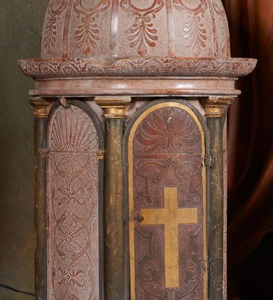 Zdjęcie nr 3: Tabernakulum na rzucie półkoła, na profilowanej podstawie, na której drewniane toskańskie kolumny podtrzymujące belkowanie z wydatnym gzymsem ozdobionym gładkimi arkadkami wypełnionymi rozetkami. Między kolumnami półkoliście zakończone drewniane arkady wypełnione ściankami. W środkowej, drewnianej, imitującej marmur, pełniącej funkcję drzwiczek, intarsjowany krzyż z jasnego drewna, otoczony symetryczną dekoracją z gładką wicią roślinną i palmetą w podłuczu.Ścianki boczne marmurowe z dekoracją groteskową (wicie arabeski przechodzące w abstrakcyjne głowy ptaków) i stylizowaną muszlą palmetową w podłuczu. Kopuła pokryta gładkimi żebrami prowadzonymi dośrodkowo, między którymi dekoracja roślinno-geometryczna.