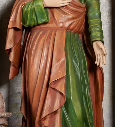 Zdjęcie nr 8: W centrum krzyż z figurą Chrystusa umarłego. Postać w lekkim zwisie o szeroko rozłożonych ramionach, głowa opada na prawe ramie. Twarz szczupła, wyraźnie rzeźbiona, okolona krótką brodą; oczy zamknięte, długi nos, usta delikatnie rozchylone. Włosy w postaci delikatnych loków opadają na ramię i plecy. Ciało szczupłe, ascetyczne, o plastycznie kształtowanej anatomii, z zaznaczonymi śladami męki. Nogi ugięte w kolanach, stopy przebite jednym gwoździem, założone prawa na lewą. Perizonium przewiązane podwójnym sznurem, odsłaniające prawe biodro, ze zwisem na prawym boku. Po prawej stronie krzyża figura Matki Boskiej, zwrócona en face, w kontrapoście; dłonie splecione, wyciągnięte przed siebie. Twarz okrągła o wyraźnych liniach łuków brwiowych i nosa, półprzymkniętych oczach. Ubrana w różową suknię przewiązaną w talii oraz granatowy płaszcz podbity czerwoną podszewką, zarzucony diagonalnie na lewe ramię i opadający na prawą nogę. Na głowie biały welon. Po lewej stronie krzyża figura św. Jana, zwrócona en face, w kontrapoście, o esowato wygiętej sylwetce; prawą rękę trzyma na piersi, lewa pozostaje opuszczona wzdłuż ciała. Twarz pełna, młodzieńcza, podkreślone linie łuków brwiowych i nosa. Włosy długie, falowane, opadają na ramiona. Ubrany w zieloną tunikę oraz czerwony płaszcz przerzucony diagonalnie przez prawy bok, przewiązane w talii. Polichromia naturalistyczna, perizonium złocone.Grupa na tle malowanego miasta oraz skłębionego szaroróżowego nieba.