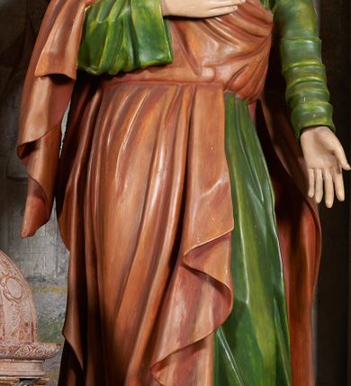 Zdjęcie nr 7: W centrum krzyż z figurą Chrystusa umarłego. Postać w lekkim zwisie o szeroko rozłożonych ramionach, głowa opada na prawe ramie. Twarz szczupła, wyraźnie rzeźbiona, okolona krótką brodą; oczy zamknięte, długi nos, usta delikatnie rozchylone. Włosy w postaci delikatnych loków opadają na ramię i plecy. Ciało szczupłe, ascetyczne, o plastycznie kształtowanej anatomii, z zaznaczonymi śladami męki. Nogi ugięte w kolanach, stopy przebite jednym gwoździem, założone prawa na lewą. Perizonium przewiązane podwójnym sznurem, odsłaniające prawe biodro, ze zwisem na prawym boku. Po prawej stronie krzyża figura Matki Boskiej, zwrócona en face, w kontrapoście; dłonie splecione, wyciągnięte przed siebie. Twarz okrągła o wyraźnych liniach łuków brwiowych i nosa, półprzymkniętych oczach. Ubrana w różową suknię przewiązaną w talii oraz granatowy płaszcz podbity czerwoną podszewką, zarzucony diagonalnie na lewe ramię i opadający na prawą nogę. Na głowie biały welon. Po lewej stronie krzyża figura św. Jana, zwrócona en face, w kontrapoście, o esowato wygiętej sylwetce; prawą rękę trzyma na piersi, lewa pozostaje opuszczona wzdłuż ciała. Twarz pełna, młodzieńcza, podkreślone linie łuków brwiowych i nosa. Włosy długie, falowane, opadają na ramiona. Ubrany w zieloną tunikę oraz czerwony płaszcz przerzucony diagonalnie przez prawy bok, przewiązane w talii. Polichromia naturalistyczna, perizonium złocone.Grupa na tle malowanego miasta oraz skłębionego szaroróżowego nieba.