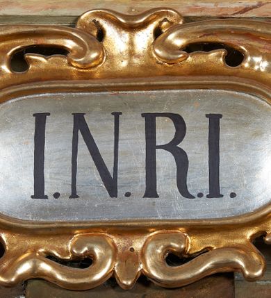 Zdjęcie nr 10: W centrum krzyż z figurą Chrystusa umarłego. Postać w lekkim zwisie o szeroko rozłożonych ramionach, głowa opada na prawe ramie. Twarz szczupła, wyraźnie rzeźbiona, okolona krótką brodą; oczy zamknięte, długi nos, usta delikatnie rozchylone. Włosy w postaci delikatnych loków opadają na ramię i plecy. Ciało szczupłe, ascetyczne, o plastycznie kształtowanej anatomii, z zaznaczonymi śladami męki. Nogi ugięte w kolanach, stopy przebite jednym gwoździem, założone prawa na lewą. Perizonium przewiązane podwójnym sznurem, odsłaniające prawe biodro, ze zwisem na prawym boku. Po prawej stronie krzyża figura Matki Boskiej, zwrócona en face, w kontrapoście; dłonie splecione, wyciągnięte przed siebie. Twarz okrągła o wyraźnych liniach łuków brwiowych i nosa, półprzymkniętych oczach. Ubrana w różową suknię przewiązaną w talii oraz granatowy płaszcz podbity czerwoną podszewką, zarzucony diagonalnie na lewe ramię i opadający na prawą nogę. Na głowie biały welon. Po lewej stronie krzyża figura św. Jana, zwrócona en face, w kontrapoście, o esowato wygiętej sylwetce; prawą rękę trzyma na piersi, lewa pozostaje opuszczona wzdłuż ciała. Twarz pełna, młodzieńcza, podkreślone linie łuków brwiowych i nosa. Włosy długie, falowane, opadają na ramiona. Ubrany w zieloną tunikę oraz czerwony płaszcz przerzucony diagonalnie przez prawy bok, przewiązane w talii. Polichromia naturalistyczna, perizonium złocone.Grupa na tle malowanego miasta oraz skłębionego szaroróżowego nieba.