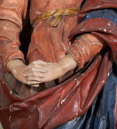 Zdjęcie nr 6: W centrum krzyż z figurą Chrystusa umarłego. Postać w lekkim zwisie o szeroko rozłożonych ramionach, głowa opada na prawe ramie. Twarz szczupła, wyraźnie rzeźbiona, okolona krótką brodą; oczy zamknięte, długi nos, usta delikatnie rozchylone. Włosy w postaci delikatnych loków opadają na ramię i plecy. Ciało szczupłe, ascetyczne, o plastycznie kształtowanej anatomii, z zaznaczonymi śladami męki. Nogi ugięte w kolanach, stopy przebite jednym gwoździem, założone prawa na lewą. Perizonium przewiązane podwójnym sznurem, odsłaniające prawe biodro, ze zwisem na prawym boku. Po prawej stronie krzyża figura Matki Boskiej, zwrócona en face, w kontrapoście; dłonie splecione, wyciągnięte przed siebie. Twarz okrągła o wyraźnych liniach łuków brwiowych i nosa, półprzymkniętych oczach. Ubrana w różową suknię przewiązaną w talii oraz granatowy płaszcz podbity czerwoną podszewką, zarzucony diagonalnie na lewe ramię i opadający na prawą nogę. Na głowie biały welon. Po lewej stronie krzyża figura św. Jana, zwrócona en face, w kontrapoście, o esowato wygiętej sylwetce; prawą rękę trzyma na piersi, lewa pozostaje opuszczona wzdłuż ciała. Twarz pełna, młodzieńcza, podkreślone linie łuków brwiowych i nosa. Włosy długie, falowane, opadają na ramiona. Ubrany w zieloną tunikę oraz czerwony płaszcz przerzucony diagonalnie przez prawy bok, przewiązane w talii. Polichromia naturalistyczna, perizonium złocone.Grupa na tle malowanego miasta oraz skłębionego szaroróżowego nieba.