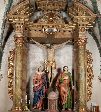 Zdjęcie nr 1: Ołtarz architektoniczny, jednoosiowy, jednokondygnacyjny, ze zwieńczeniem. Mensa drewniana z marmurowym portatylem, na prostopadłościennej skrzyni. Antepedium ujęte profilowaną ramą z malowanym obramieniem w polu oraz literami IHS. Retabulum ujęte parą kolumn o kapitelach kompozytowych, na cokołach, dźwigających występujące nad podporami pełne belkowanie i wydatny gzyms oraz przerwany półkolisty przyczółek. W polu środkowym rzeźbiona Grupa Ukrzyżowania na malowanym tle. W zwieńczeniu serce gorejące w glorii promienistej. Zwieńczenie ujęte spływami wolutowymi i cęgami, zamknięte gzymsem wygiętym łukiem odcinkowym. Cokoły kolumn zdobione płycinami z dekoracją roślinną. Nastawa flankowana uszami utworzonymi z motywów mięsistego akantu. Fryz dekorowany uskrzydlonymi główkami anielskimi. Nastawa i antepedium marmoryzowane w odcieniach seledynowych i beżoworóżowych, detale architektoniczne i ornamentyka złocone.
