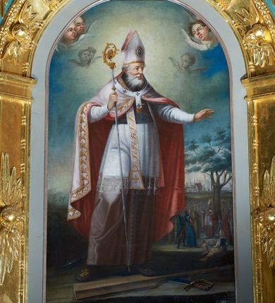 Zdjęcie nr 1: Obraz w kształcie stojącego prostokąta zamkniętego łukiem półkolistym. W centrum kompozycji ukazany św. Wojciech zwrócony en trois quarts w lewo, z pastorałem w prawym ręku i lewą ręką wysuniętą przed siebie, z głową zwróconą w lewo. Święty ubrany w szaty pontyfikalne: długą sutannę, białą komżę oraz białą kapę z czerwoną podszewką; na szyi przewieszona biała stuła ze złotym haftem oraz palisz; na głowie infuła. Twarz ukazana z lewego profilu, okolona długą, gęstą i siwą brodą. W dolnej partii obrazu leżące na ziemi wiosło oraz szabla. W tle ukazana scenka nauczania przez św. Wojciecha. W górnej partii obrazu błękitne niebo i wyłaniające się z obłoków uskrzydlone główki anielskie.